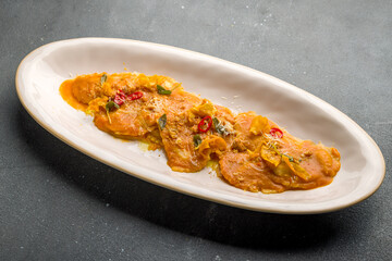 orange ravioli with pumpkin on grey concrete table