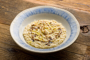 risotto four cheeses on plate on wooden table