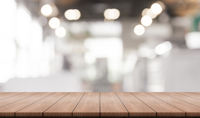 Empty wooden table top with lights bokeh on blur restaurant background.