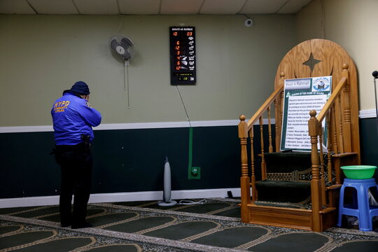 An NYPD officer with the Community Affairs department prays inside the Masjid Ar Rahmah mosque close to the multi-level apartment building fire in the Bronx borough of New York City, New York