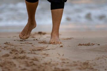 Beach travel concept. Legs on Tropical Sand Beach. Walking Feet. Closeup