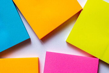 Cozy home office desk with beige blanket, cup of coffee, clipboard with empty paper note on white background. Flat lay, top view. Hygge or nordic style feminine workspace.