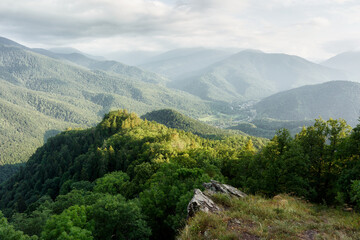 Fototapeta na wymiar mountains with a forest in the Caucasus mountains, a view from the topto a mountain village in the valley