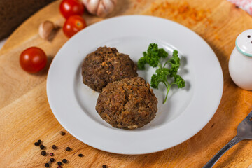 lamb and beef meat cutlets on a white plate in a cafe