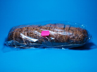 Bread loaf with price sticker. Fluctuations in grain prices. Rising food prices. Bread in a package on a blue background
