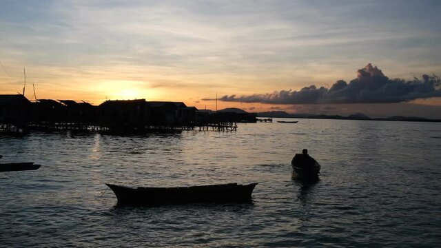 The traditional Bajau stilt house at Pulau Omadal, Semporna, Malaysia during sunset time with silhouette of the houses. The Bajau are a seafaring population in Southeast Asia