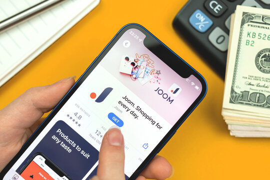 Joom app icon closeup. Woman uses the application on Apple iPhone 12