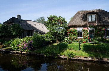 Fototapeta na wymiar View of typical houses of Giethoorn, Netherlands. The beautiful houses and gardening city is know as 