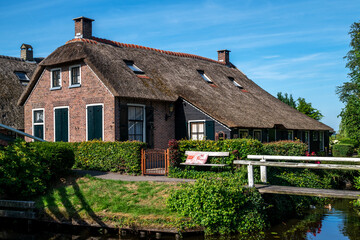 Fototapeta na wymiar View of typical houses of Giethoorn, Netherlands. The beautiful houses and gardening city is know as 