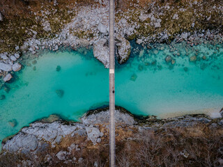 Two people standing on bridge over the beautiful turquoise Soca (Soča) River during Winter in Slovenia, Europe