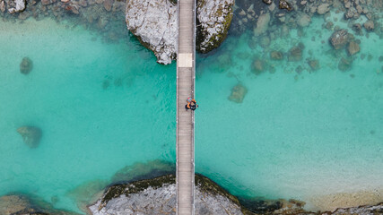 Lovely couple standing together on bridge over crystal blue Soca river, Slovenia
