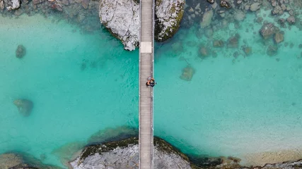 Fototapeten Lovely couple standing together on bridge over crystal blue Soca river, Slovenia © Tom H