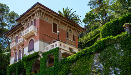 Fototapeta na wymiar Eco architecture with plants and flowers on the facade. Ecology and green environment concept. Colorful mediterranean buildings in spectacular resort, Liguria, Italy, Europe. 