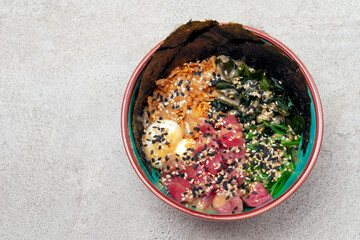 poke salad with tuna is a traditional food of Hawaiian and Japanese cuisine in a plate top view, copy space.