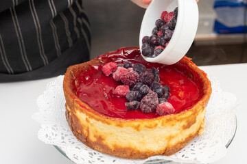 step by step elaboration of the cheesecake cake decorated by chef a manga with cream and red berries