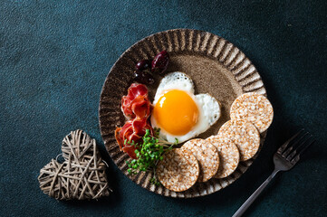 Breakfast on Valentine's Day - fried eggs in the shape of a heart and olives. Healthy breakfast. Rice cakes with eggs and hamon. Romantic breakfast. Top view.