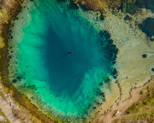 One diver in the blue hole Izvor Cetine, Dalmatia. Aerial top down shot in April, 2021.