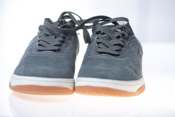 Mens gray leather sneakers on a light background.