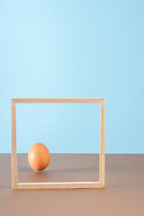 Egg on brown background whit wooden frame