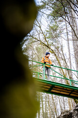 Tourist enjoying the lookout on bridge over Mostnica Gorge canyon near Bohinj, Slovenia