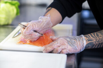 Close up of mans hands cutting fish for sushi - Powered by Adobe