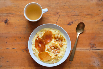 plate of sweet polenta with milk and caramelized pears, nuts.