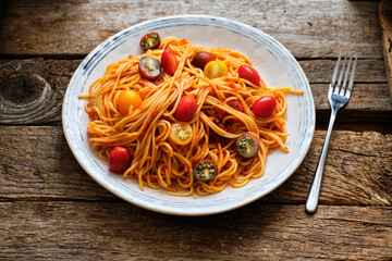 spaghetti with tomato sauce. Side view, wooden background, horizontal