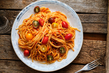 spaghetti with tomato sauce. Side view, wooden background, horizontal