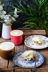 Cake pigeon's milk. Sponge cake and tender soufflé, creamy mousse. Garnished with milk chocolate and peanut. Side view, wooden background and coffee.