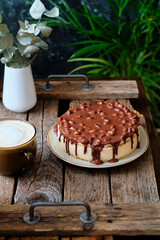 Cake pigeon's milk. Sponge cake and tender soufflé, creamy mousse. Garnished with milk chocolate and peanut. Side view, wooden background and coffee.