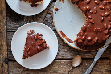 Chocolate Cake. Sponge cake and tender soufflé, creamy mousse. Garnished with milk chocolate and peanut. Top view, horizontal,  wooden background and coffee.