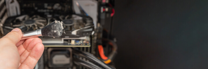 Cleaning dirty computer. Computer maintenance. Cleaning a dirty computer from dust with a special brush close-up. Place for your text. Banner for advertising and website header.