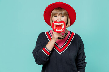 Full body cheerful elderly woman 50s wearing necklace shirt red hat hold scream in mouth shape lips...