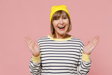 Elderly overjoyed amazed impressed stylish woman 50s wearing striped shirt yellow hat spread hands...