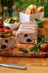 Terrine with pistachios and olives. Side view. Tomatoes, pickles, rosemary.