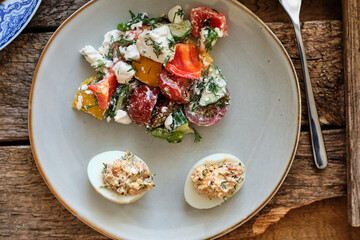 vegetable salad with feta cheese. stuffed eggs with sun-dried tomatoes.