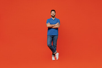 Fototapeta na wymiar Full body young smiling confident calm happy european attractive man 20s in basic blue t-shirt hold hands crossed folded isolated on plain orange background studio portrait. People lifestyle concept