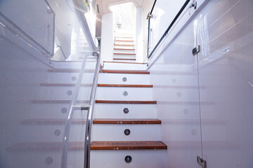 Teak steps with handrails on a luxury yacht. Teak deck of the yacht. Entrance to the second floor...
