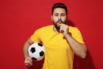 Passionate strict serious vivid young bearded man football fan wears yellow t-shirt blow whistle...
