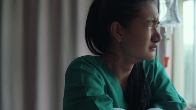 A despondent Asian woman patient. Following the doctor's declaration that the cancer was nearing the end of its course.