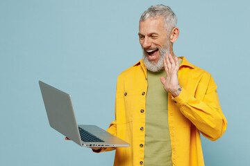 Elderly smiling cheerful happy gray-haired mustache bearded man 50s in yellow shirt hold use work...