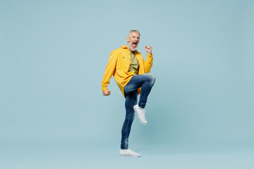 Full body excited elderly gray-haired mustache bearded man 50s wear yellow shirt doing winner gesture celebrate clenching fists say yes isolated on plain pastel light blue background studio portrait