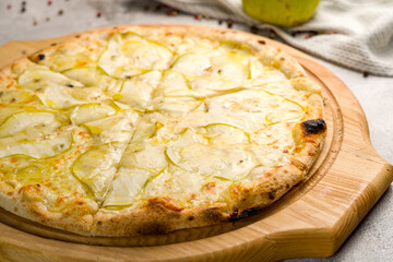 Pizza with pears and Gorgonzola cheese on the board on grey concrete table macro close up
