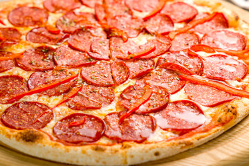 Pepperoni pizza on the board on grey concrete table macro close up