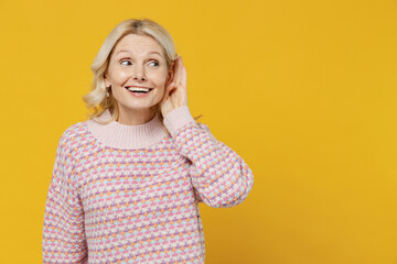 Elderly curious nosy smiling blonde caucasian woman 50s in pink sweater try to hear you overhear...