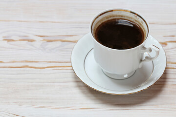 Cup of coffee on white wooden table, copy space.