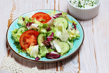Healthy salad with lettuce, tomatoes and cucumbers.