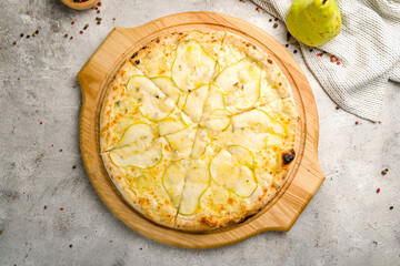 Pizza with pears and Gorgonzola cheese on the board on grey concrete table top view