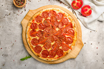 Pepperoni pizza on the board on grey concrete table top view