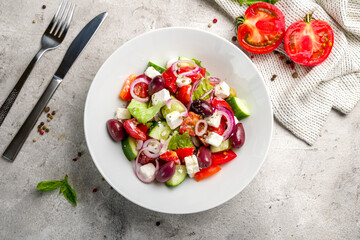 Greek salad with feta and vegetables top view on grey concrete table